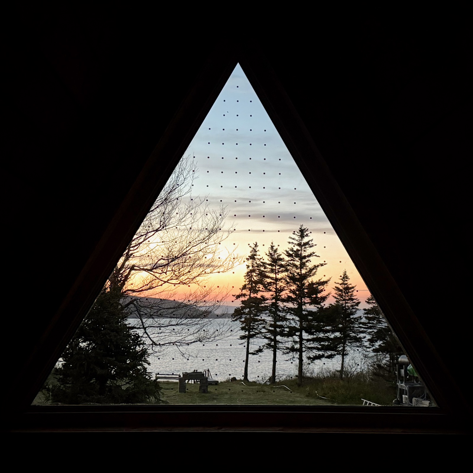 Sunset over the water seen through the triangular loft window